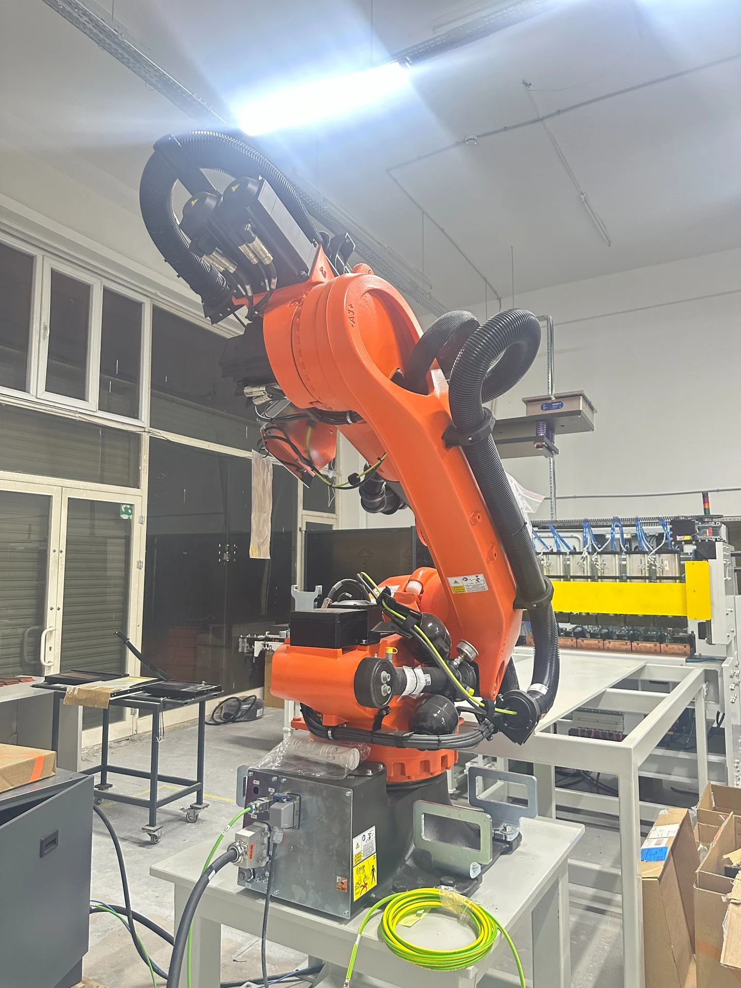 Braccio robotico arancione con utensile in officina