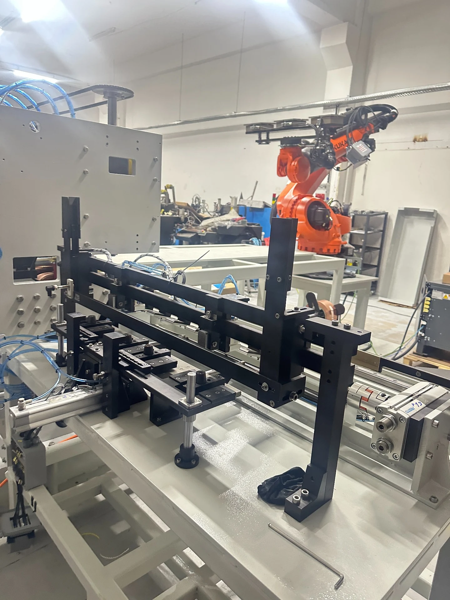 Macchinari in officina con braccio robotico arancione sullo sfondo