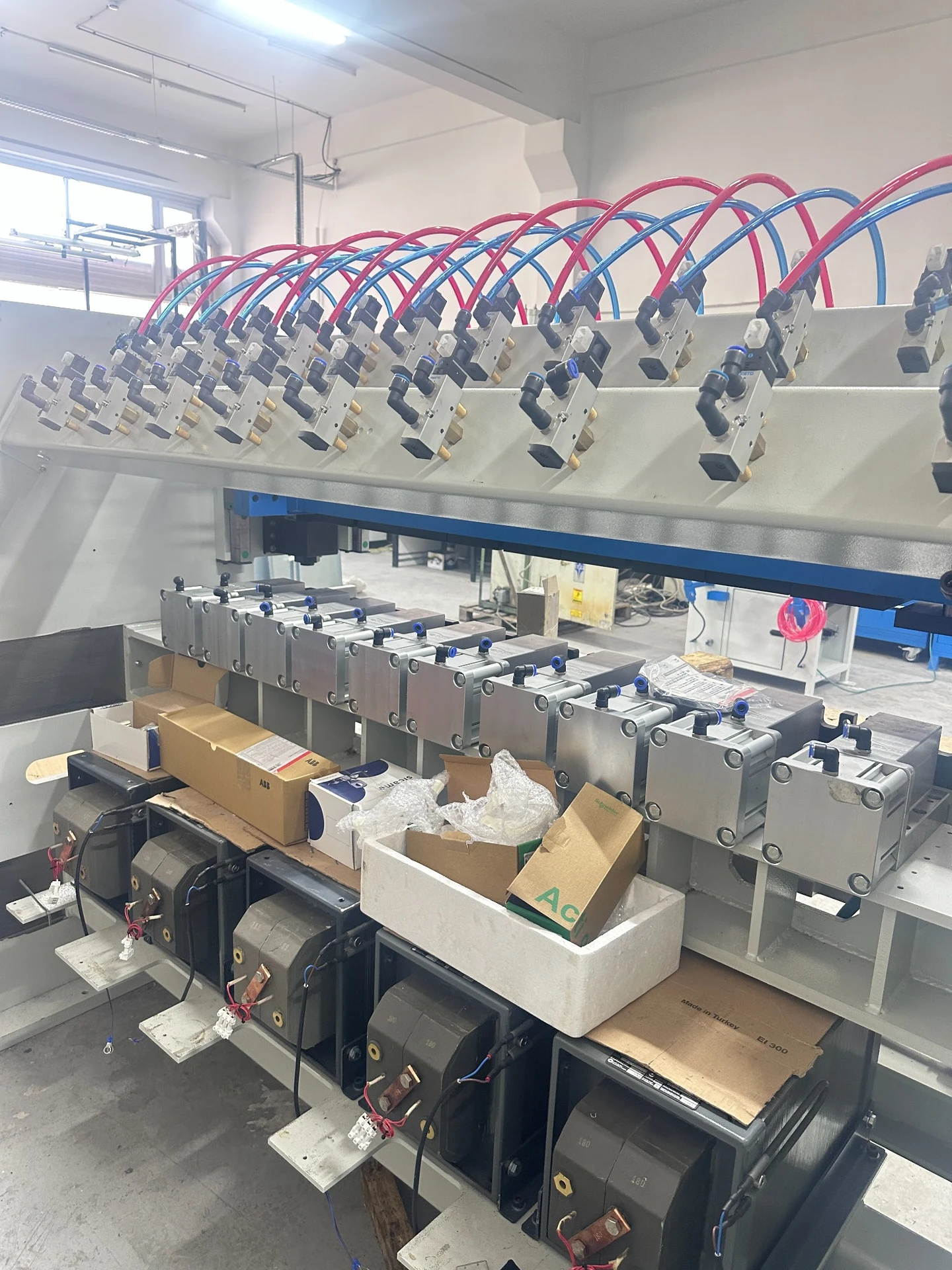Fila di stazioni macchina con tubi blu e rossi