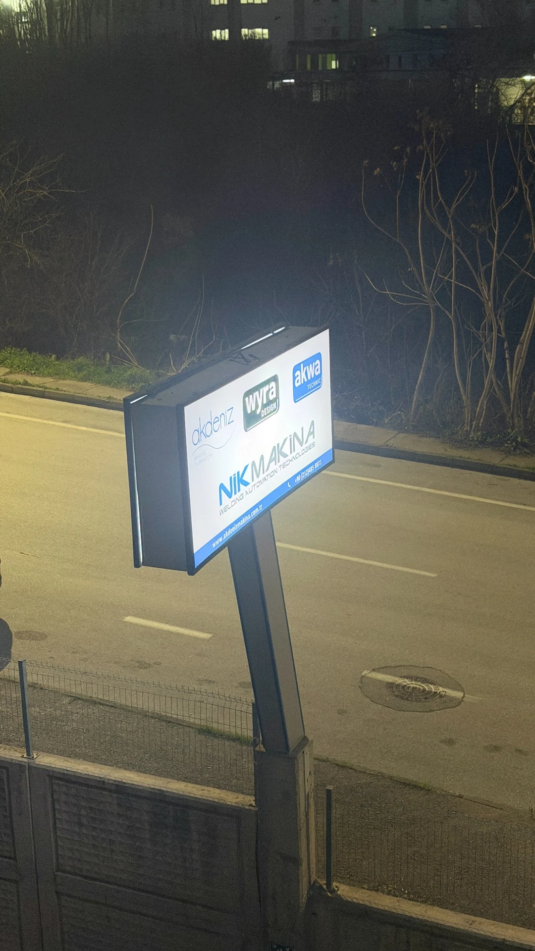 Insegna aziendale illuminata lungo la strada di notte